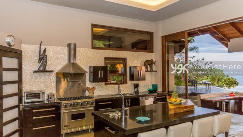 Modern and sleek kitchen at the Jade House with island and bar and a walk-in pantry.