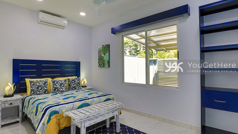 Bright and modern guest bedroom at Bella Vita with lovely blue wooden shelving and headboard.