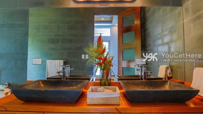 Modern guest bath in Villa Oro Verde with fresh tropical flowers in vase.