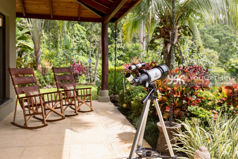 Outdoor patio with locally made rocking chairs and telescope for star gazing at Villa Koora.