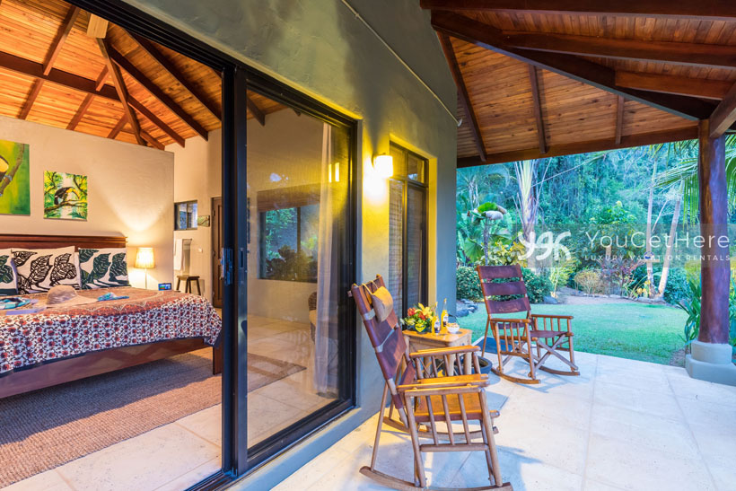 Sliding door from Villa Koora guest bedroom to patio with rocking chairs.