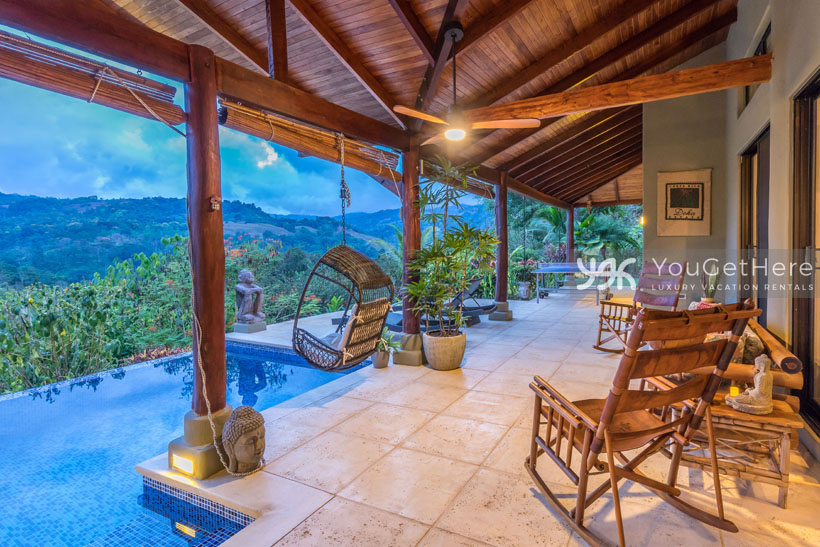 Large patio with tropical potted plants and custom local rocking chairs at Villa Koora.