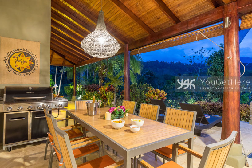 Outdoor dining table and BBQ with lovely overhead chandelier at Villa Koora Vacation Villa Costa Rica.