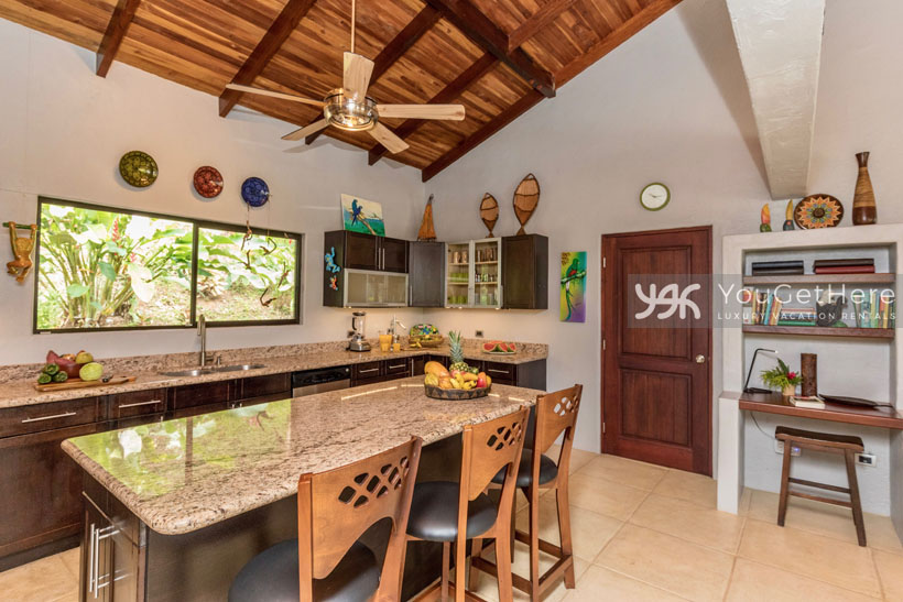 Villa Koora kitchen area with island bar and three barstools.