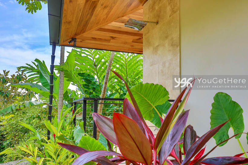 Outdoor rainfall shower on the pool deck surrounded by lovely tropical landscaping.