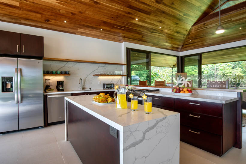 Clean and bright kitchen with island and bar in Villa Dalu Costa Rica.