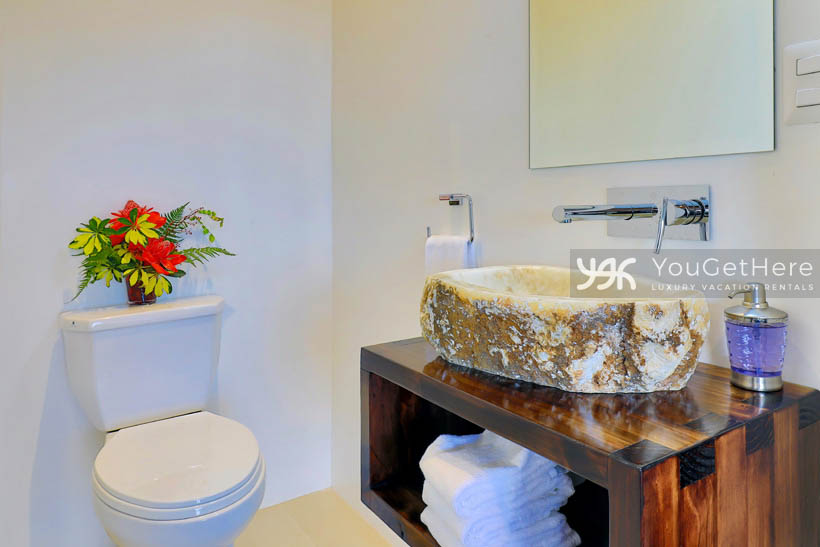 Villa Dalu guest bathroom with unique stone sink and lovely wood cabinetry.