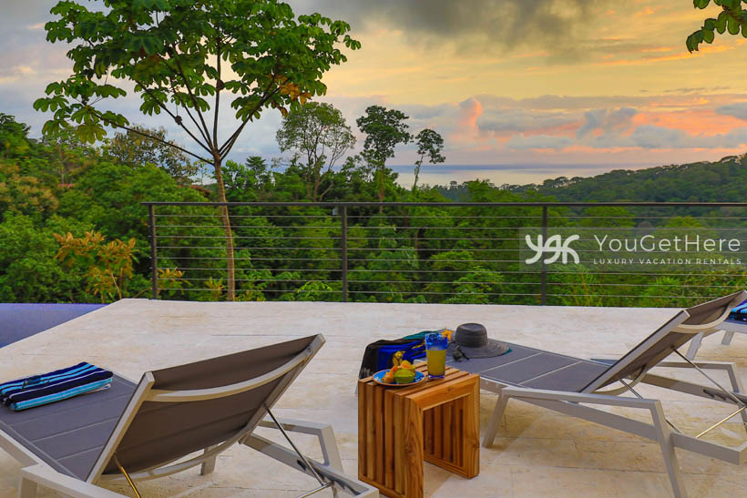 Ocean view over jungle canopy and lounge chairs at Villa Dalu Costa Rica.