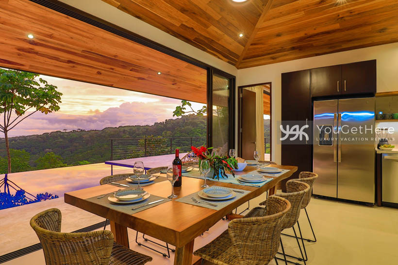 Large dining table set for eight overlooking the pool and jungle at Villa Dalu Costa Rica.