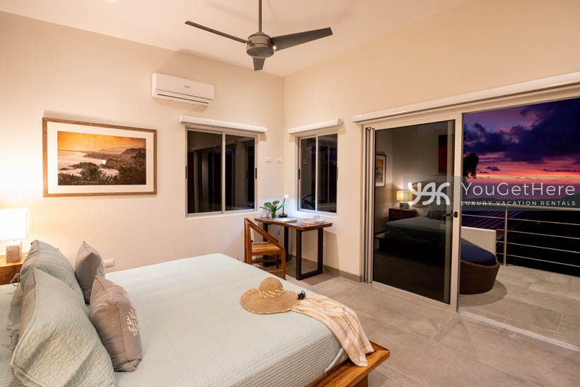 Tulu Azul Costa Rica guest bedroom at sunset with amazing purple skies out slider onto balcony.