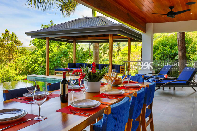 Tulu Azul Costa Rica brightly colored seating around large dining table for eight, with ceiling fans overhead.