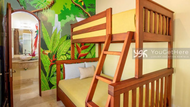 Vista Encanto Costa Rica guest room perfect for kids with bunkbeds and wall art of jungle plants sloth and toucan.