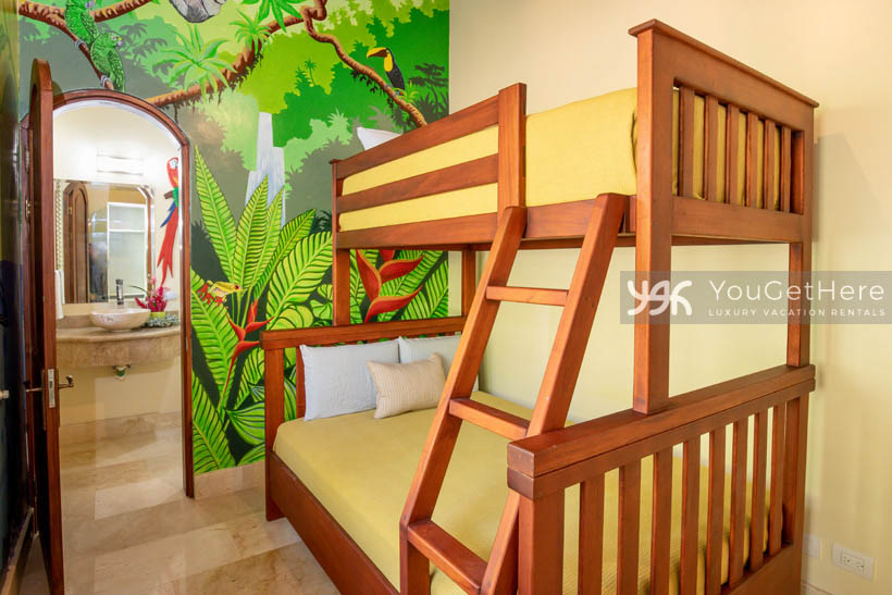 Vista Encanto Costa Rica guest room perfect for kids with bunkbeds and wall art of jungle plants sloth and toucan.