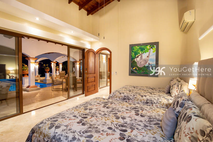 Vista Encanto Costa Rica guest bedroom with two queen size comfortable beds and sliders out to pool deck.
