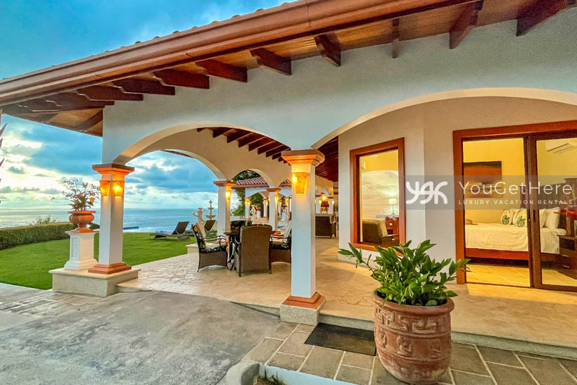 Grass are with lounge chairs next to covered outdoor patio space at Vista Encanto Costa Rica.