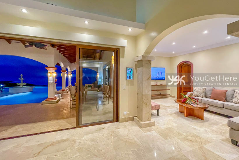 Beautifully tiled living room with disappearing sliders leading onto pool deck.