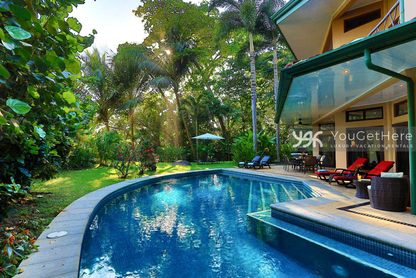 Pool deck patio at Caballitos del Mar with ample seating, lounge chairs and outdoor dining table.