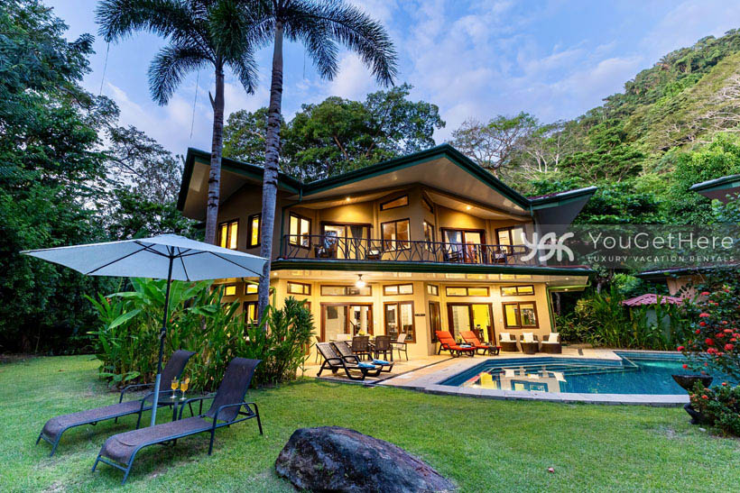 Caballitos del Mar Norte nighttime view of spacious backyard, lighted pool and stunning vacation home.