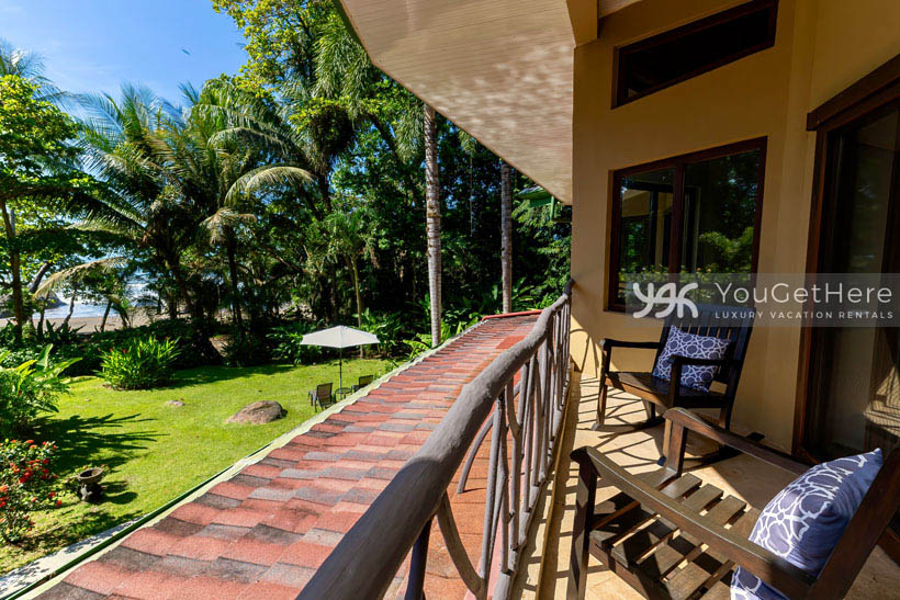 Beachfront vacation villa Caballitos del Mar Norte balcony rocking chairs on a sunny blue sky morning.