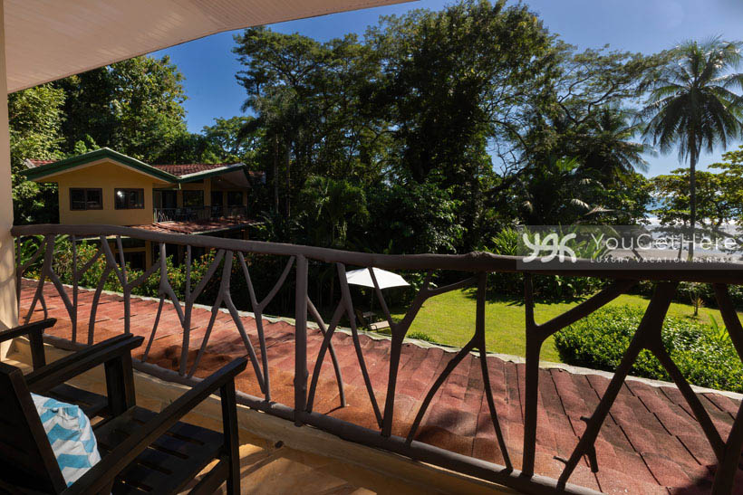 View of a sunny day at the beach from the second floor balcony chairs at Caballitos del Mar Complex in Costa Rica.