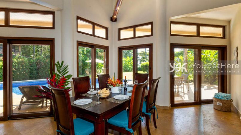 Caballitos del Mar Central dining room with view onto pool deck and grassy backyard.