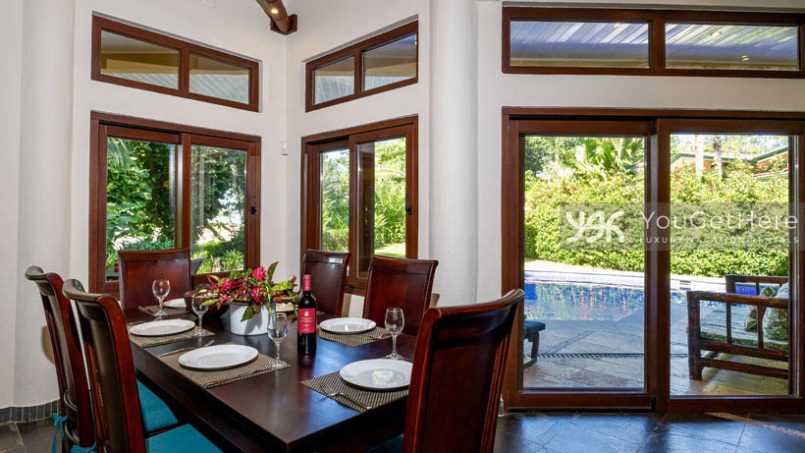 Caballitos del Mar Sur dining room with view onto pool deck and grassy backyard.