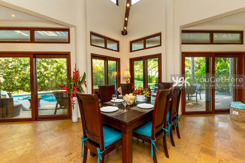 Open spacious dining room with bamboo lighting overhead and view of pool deck and backyard.