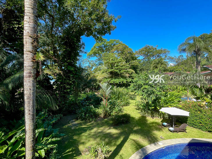 A sunny day in the backyard at Caballitos del Mar Complex with two lounge chairs and an umbrella.