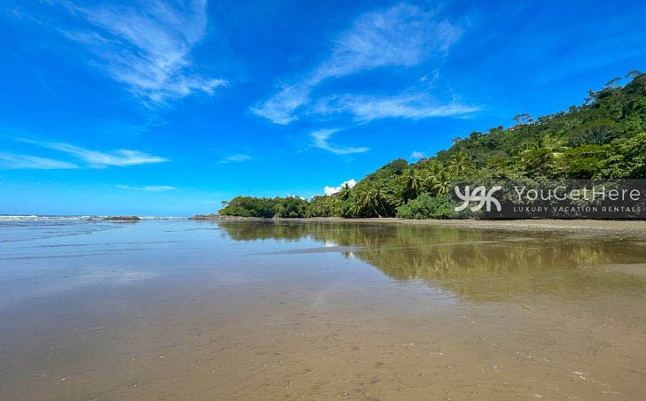 The beach in front of Caballitos del Mar Central on a sunny blue sky day in Costa Rica.
