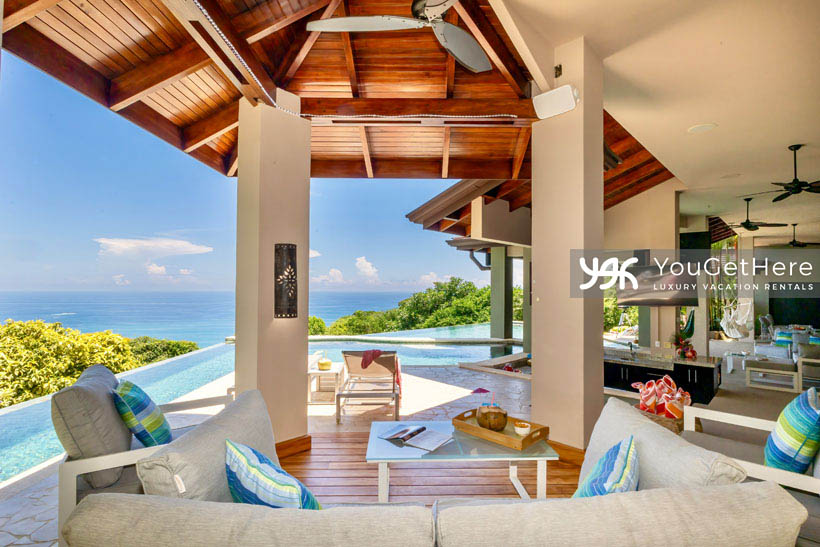 Jade house Costa Rica outdoor BBQ area with ample comfortable seating under covered stunning wood ceiling.