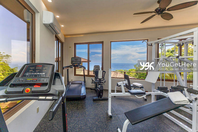 Jade House Costa Rica exercise room with ocean view cardio equipment, two treadmills and sit down bike as well as weight lifting machine.