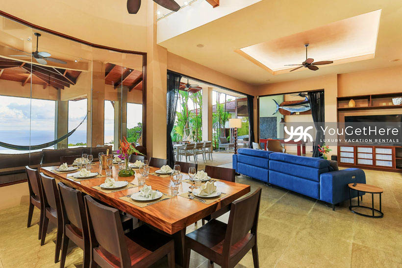 Jade House Costa Rica huge wooden indoor dining set for ten under ceiling fan and vaulted ceiling with view to second floor walkway.