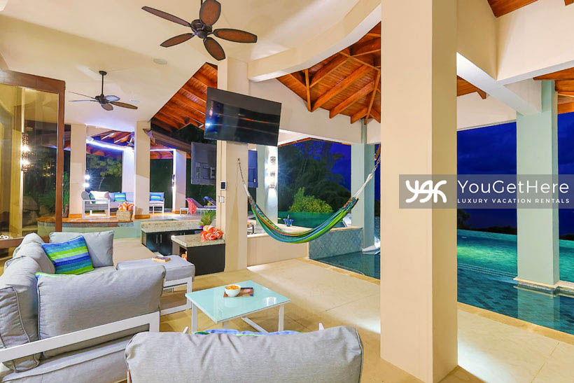 Jade House Costa Rica outdoor deck with hamocks, oversized comfortable couches, ceiling fans and two mounted televisions.