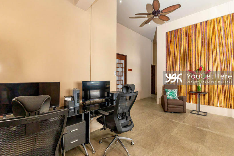 Jade House Costa Rica office with two desks featuring ergonomic chairs, widescreen displays overhead fans and energizing wall art throughout.