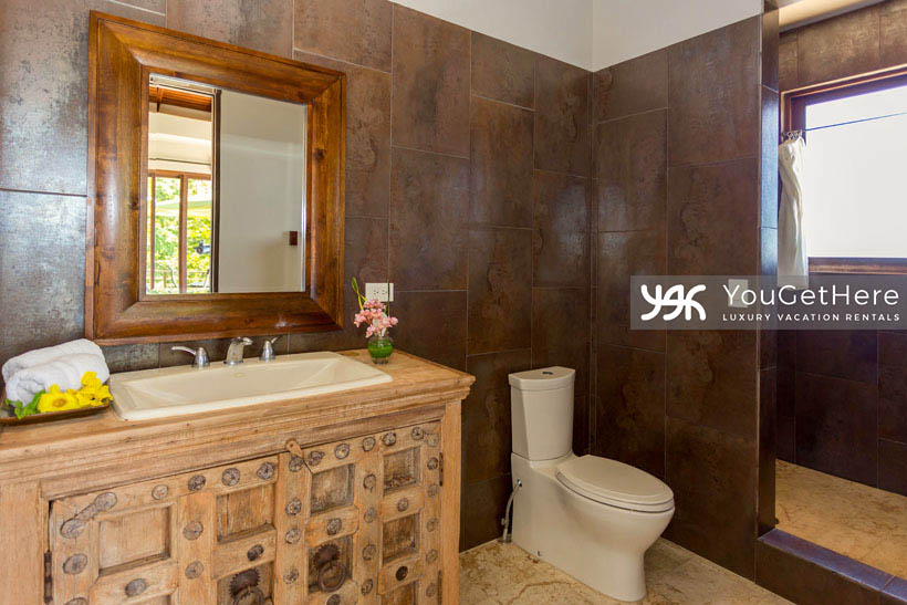 Jade House Costa Rica newly renovated guest bathroom with bespoke vintage style wooden cabinetry and walk-in shower with spectacular views and dark stone tiling.
