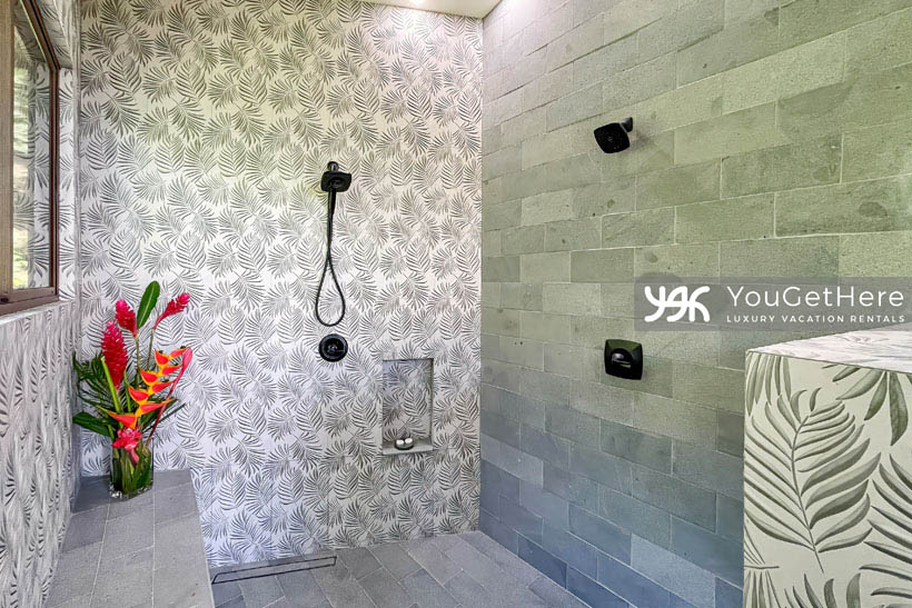 Jade house guest bathroom with dual shower heads and beautiful stone detailing.