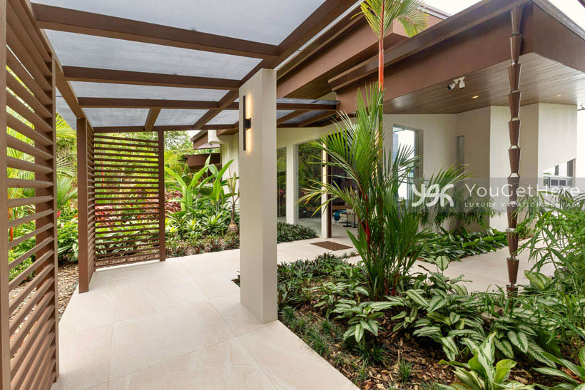 Lovely wood craftsmanship adorns the tropically landscaped exterior walkways at upscale Costa Rica vacation villa.