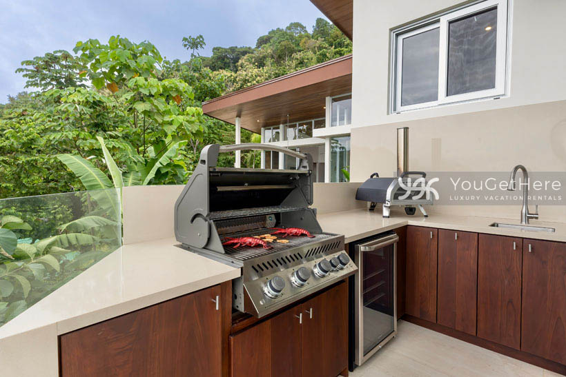 Outdoor built in BBQ and wine fridge, sink and cabinetry make cooking outdoors a breeze at this luxury vacation rental in Costa Rica.