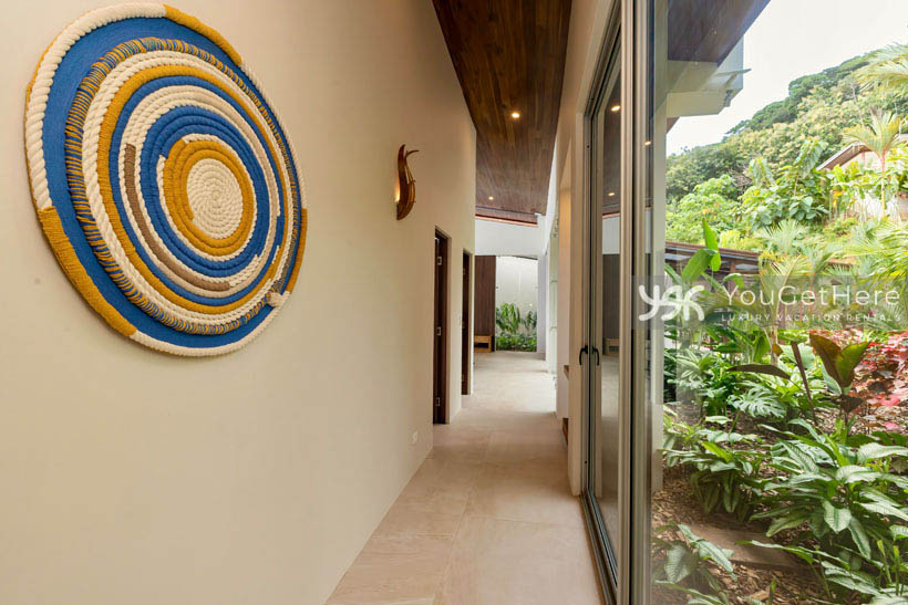 Thoughtfully decorated walkways feature lighted sconces and beautifully landscaped green areas of luxury Costa Rica vacation home.