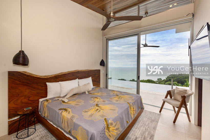 Ocean-view guest suite in Costa Rica rental villa with balcony overlooking stunning jungle landscapes.