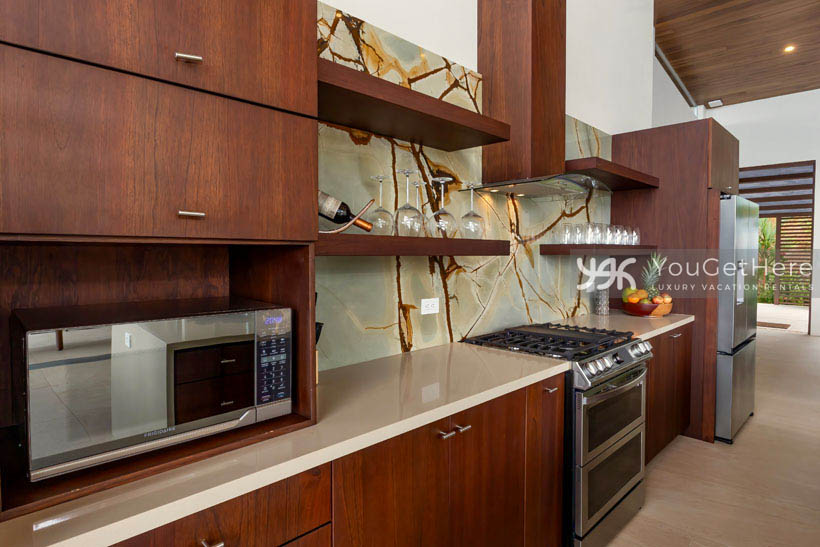 Stunning kitchen in upscale Costa Rica vacation villa featuring unique stone back-splash tiling and all new appliances.