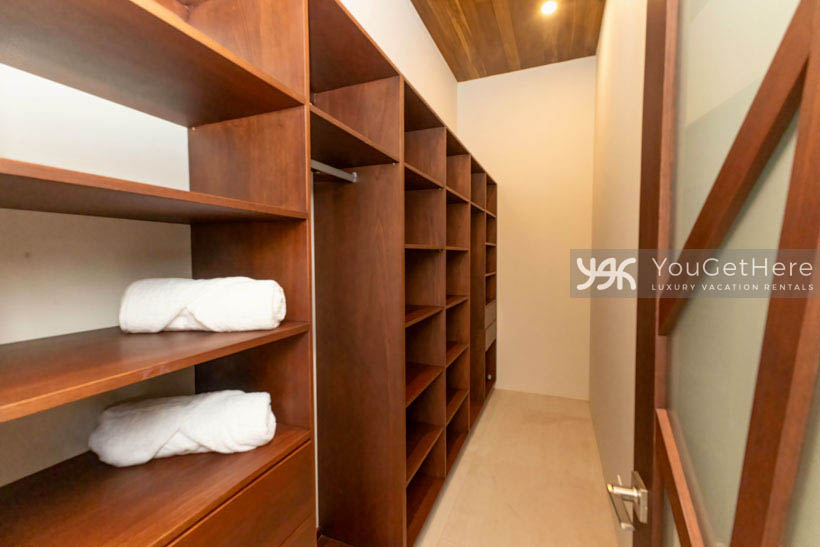 Beautiful custom wood shelving and recessed overhead lighting in master walk-in closet of Costa Rica Luxury Villa Vacation Rental.