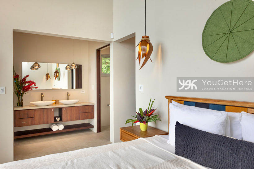 Lovely decor and tropical flowers adorn comfortable and sleek guest bedroom at Costa Rica Vacation Home.