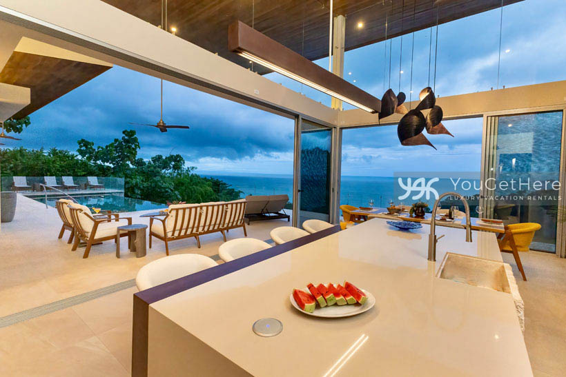 Floor to ceiling panoramic ocean view and skyline windows from kitchen island bar seating four.