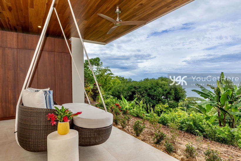 Beautiful luxurious ocean view vacation rental in Costa Rica with hanging lounge chair overlooking a tropical garden.