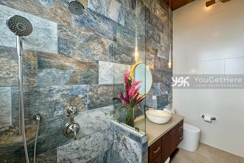 Vacation home in Costa Rica with beautiful stone tile from floor to ceiling in guest bathroom.