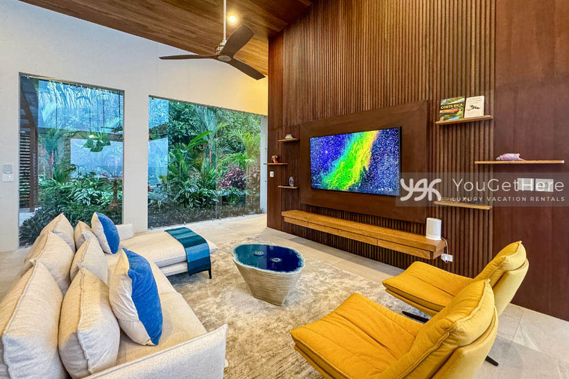 Costa Rica luxury vacation rental with stunning garden view windows in living room.